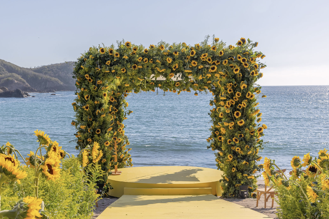 A sunflower chuppah by the sea, bright and open